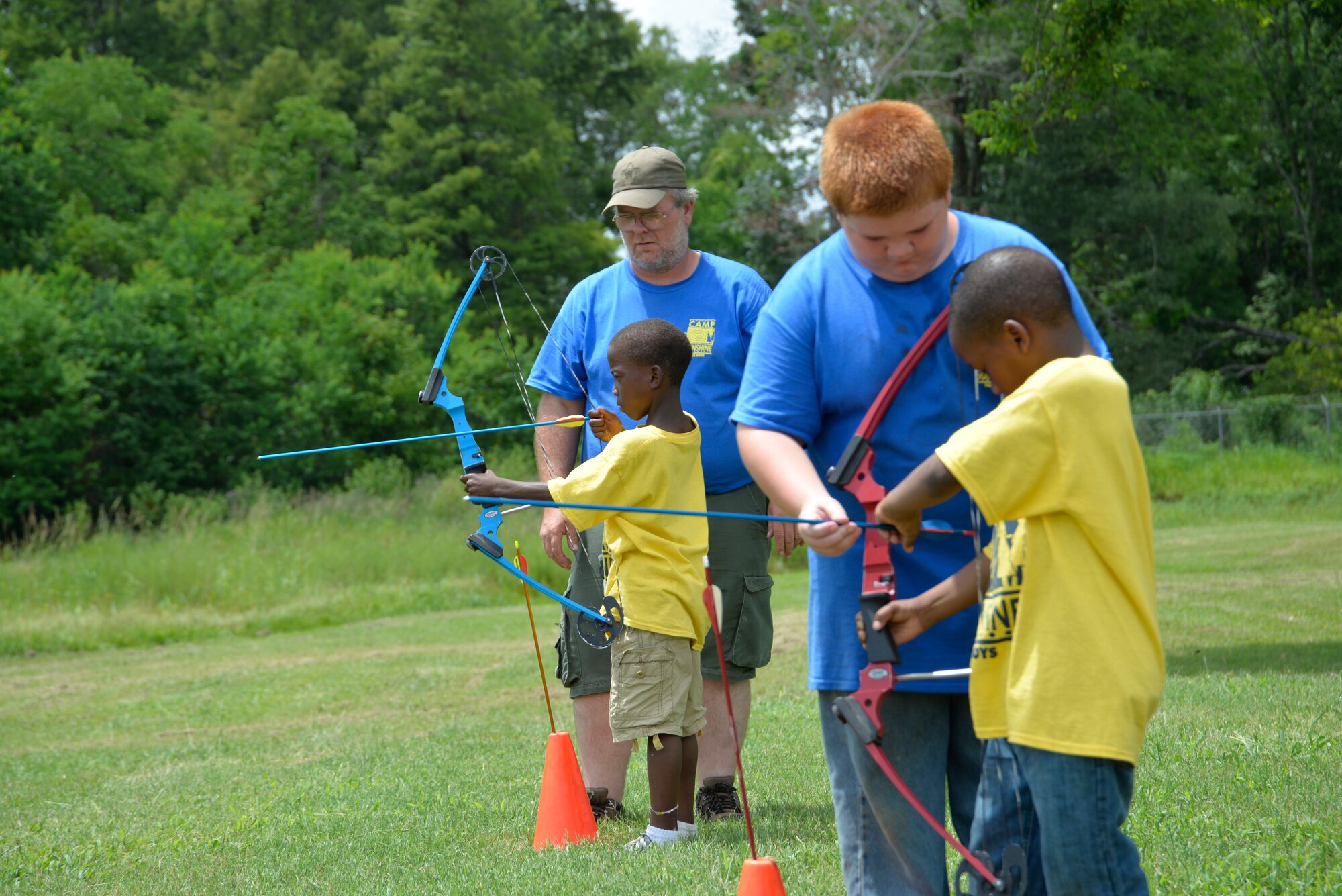 Tukabatachee Area Boy Scouts of America members show Montgomery Public Housing Community members archery techniques during the 12th annual Camp Sunshine Program at Maxwell Air Force Base July 22, 2014. Camp Sunshine is a week-long camp for boys from various neighborhoods in the River Region community. During the camp, Maxwell Airmen and the boy scouts mentor and guide the boys through various activities. (U.S. Air Force photo by Staff Sgt. Erica Picariello)