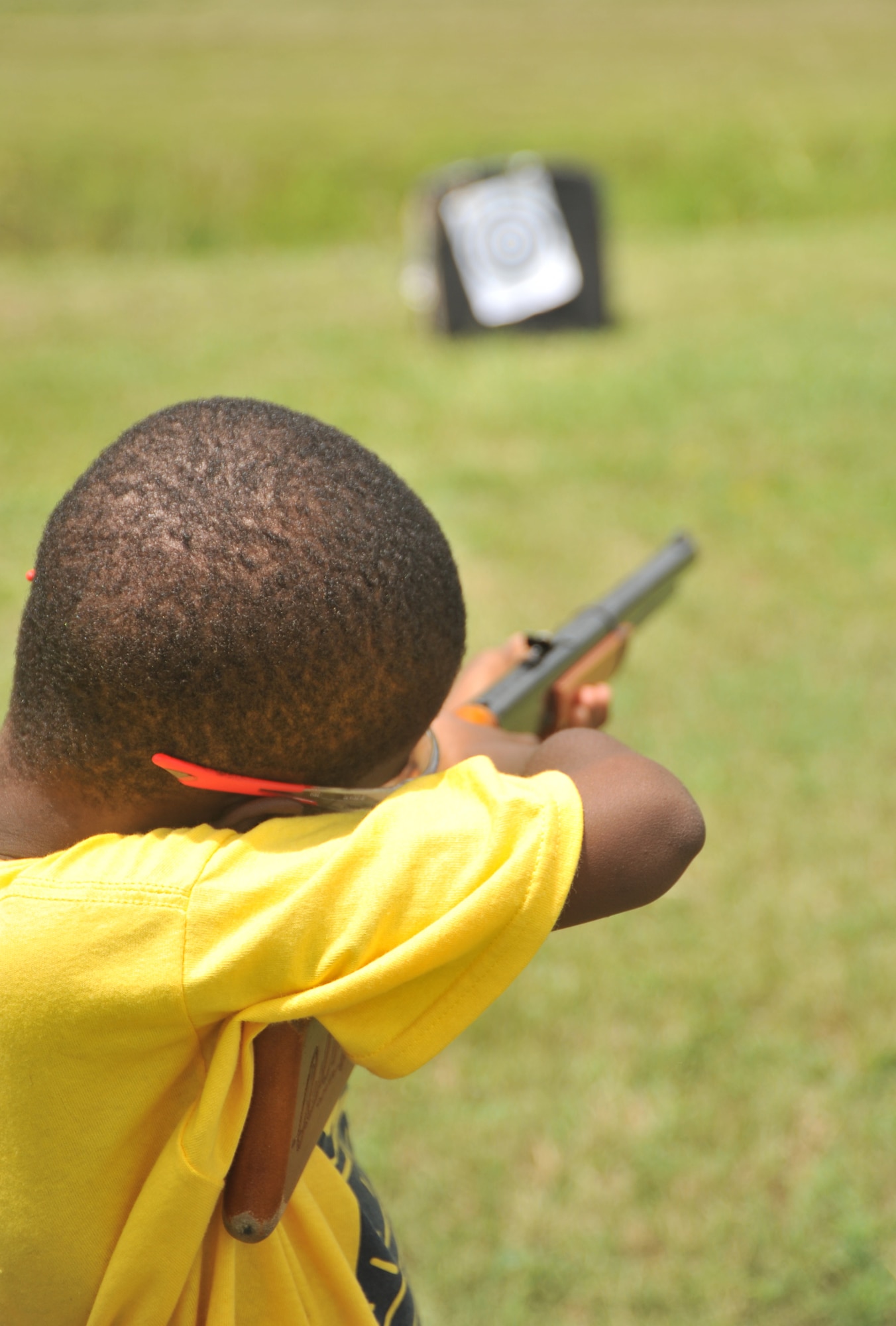 A Camp Sunshine participant fires his toy-rifle at a target during the week-long event hosted on Maxwell Air Force Base July 22, 2014. This is the 12th year Maxwell is hosting the Camp Sunshine Program. The annual program allows Airmen to mentor local area boys through a week of activities including swimming, basketball and arts and crafts. (U.S. Air Force photo by Master Sgt. Michael Voss)