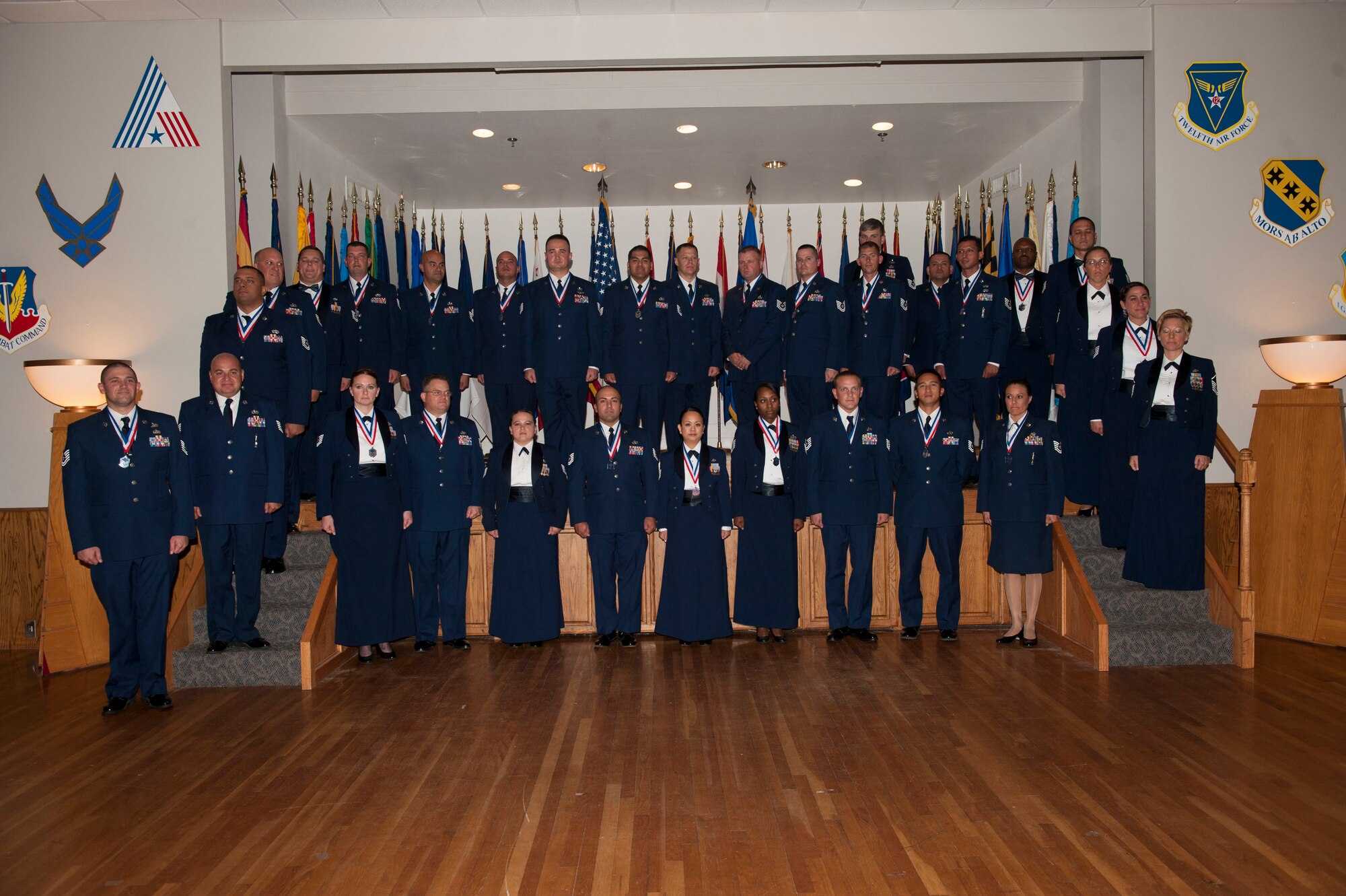 U.S. Air Force Airmen prepare to sing the Air Force song at the conclusion of their Senior Noncommissioned Officer Induction Ceremony July 18, 2014, at Dyess Air Force Base, Texas.  Prior to their induction into the senior NCO corps, Airmen attended a professional enhancement seminar designed to augment and enhance supervisory and leadership skills, focusing on motivation and counseling, military writing and the enlisted force structure. Thirty-one Airmen who were recently selected for promotion to master sergeant or recently promoted to the grade of E-7 were inducted during the ceremony. (U.S. Air Force photo by Airman 1st Class Kylsee Wisseman/Released) 