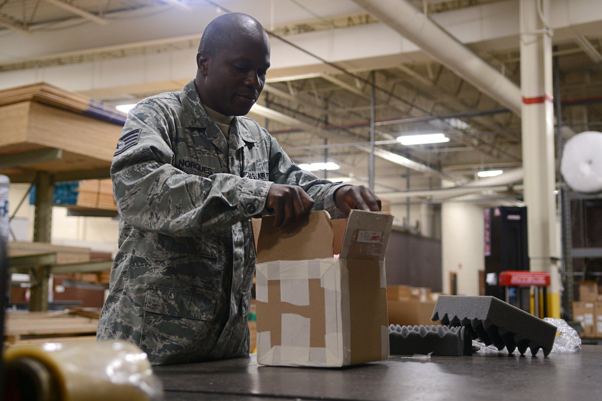 U.S. Air Force Staff Sgt. Fred Norgues, Defense Reutilization and Marketing Office outbound cargo technician, prepares a box to be reused at the DRMO out-bound processing dock at Langley Air Force Base, Va., July 28, 2014. Out-bound processing technicians use recovered shipping supplies to send out everything screws to large machinery worldwide. (U.S. Air Force photo by Airman 1st Class Devin Scott Michaels)