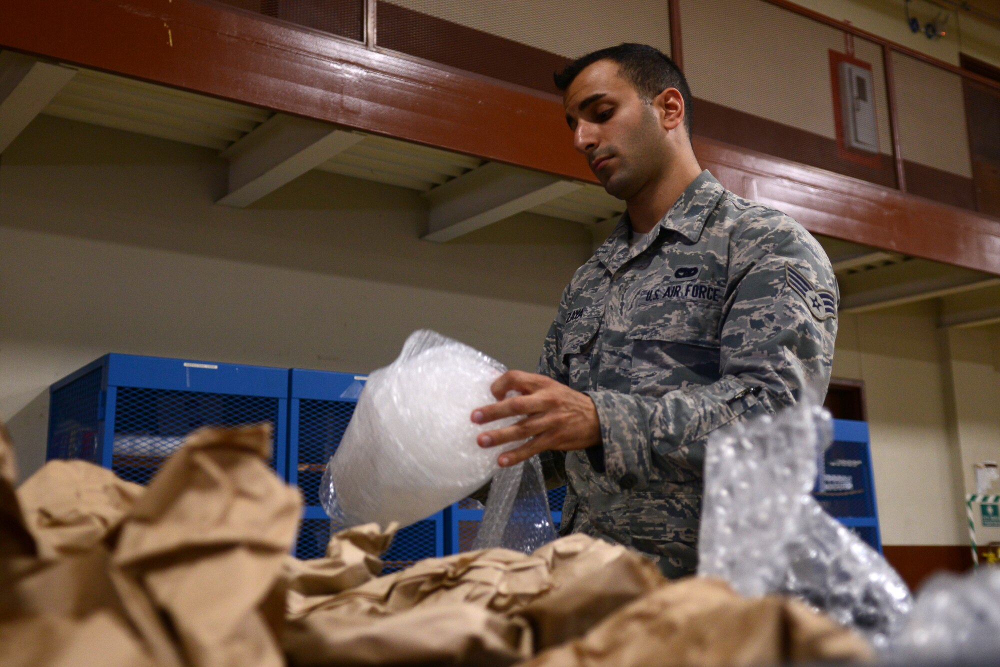 U.S. Air Force Senior Airman Sargon Zaya, Defense Reutilization and Marketing Office traffic management technician, separates used shipping materials at the DRMO inbound-processing dock at Langley Air Force Base, Va., July 28, 2014. Once supplies are received at in-bound processing, traffic management technicians remove their packaging to be appropriately repurposed, recycled or thrown away. (U.S. Air Force photo by Airman 1st Class Devin Scott Michaels)