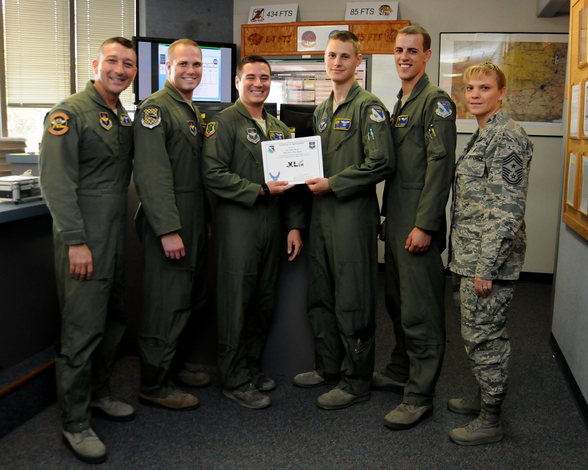 From left to right, Col. Brian Hastings, 47th Flying Training Wing commander, 1st Lt. Tyler Byrd, 1st Lt. Derek Fiebig, 1st Lt. Paul Homsher, 1st Lt. Brady Jackson, 85th Flying Training Squadron T-6A Texan II instructor pilots, and Chief Master Sgt. Teresa Clapper, 47th FTW command chief, pose for photo after the XLer award presentation at Laughlin Air Force Base, Texas, July 23, 2014. The XLer is a weekly award chosen by wing leadership and given to those who consistently make outstanding contributions to their unit and Laughlin. (U.S. Air Force photo by Airman 1st Class Ariel D. Delgado)(Released)