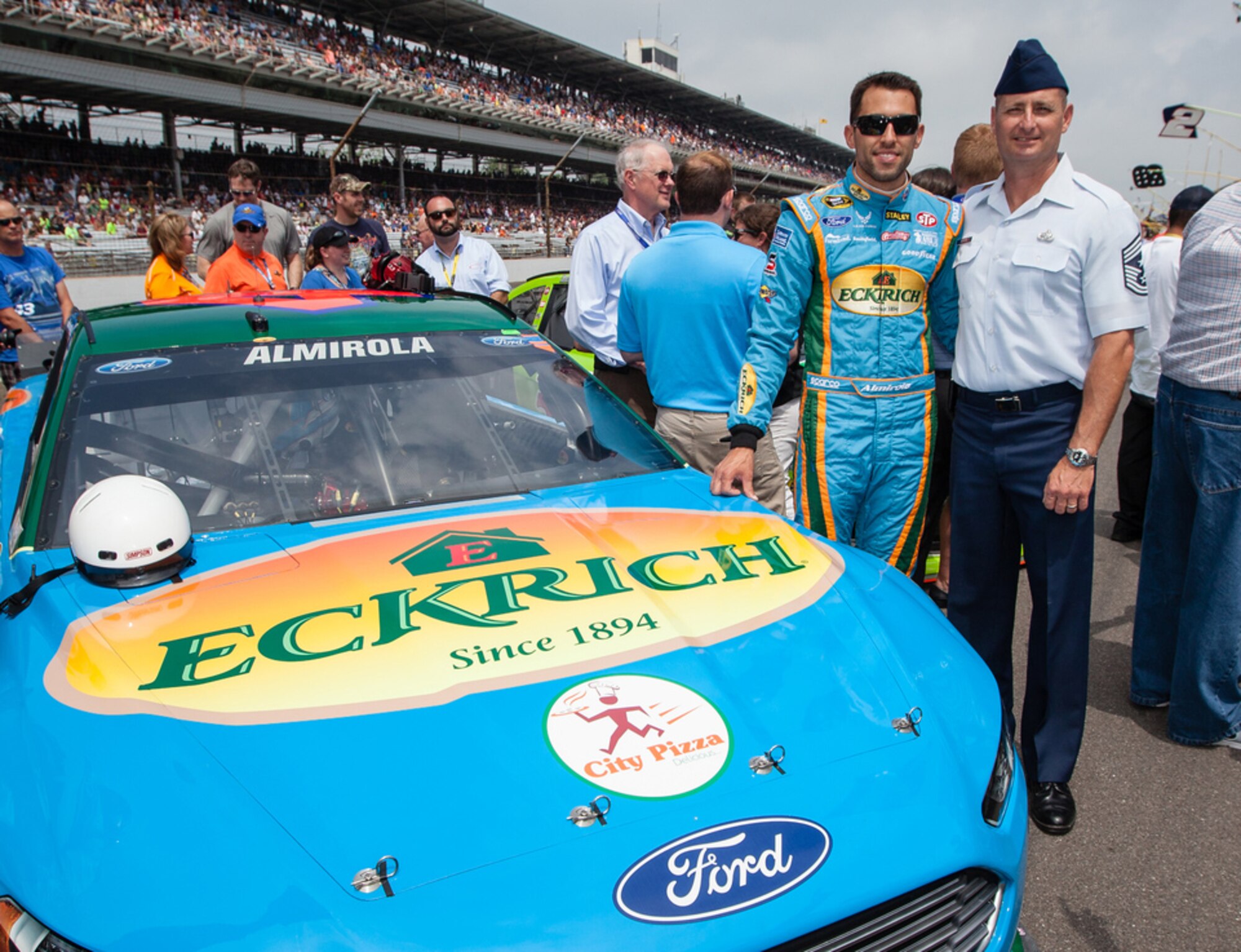 Chief Master Sergeant Raymond DeVite Jr., the command chief for the Air Force Research Laboratory, joins NASCAR driver Aric Almirola prior to the Brickyard 400 race event July 27 at Indianapolis Motor Speedway. The Air Force is a sponsor of car 43, owned by Richard
Petty Motorsports.  The Air Force partners with NASCAR as part of its
Science, Technology, Engineering and Math outreach, attracting mechanically
and technically inclined youth who attend these races. DeVite, along with AFRL commander Maj. Gen Tom Masiello, met with Air Force delayed entry program recruits and
participated in a pre-race swearing-in ceremony for the future Airmen.
(Photo courtesy of C. Brad Schloss)
