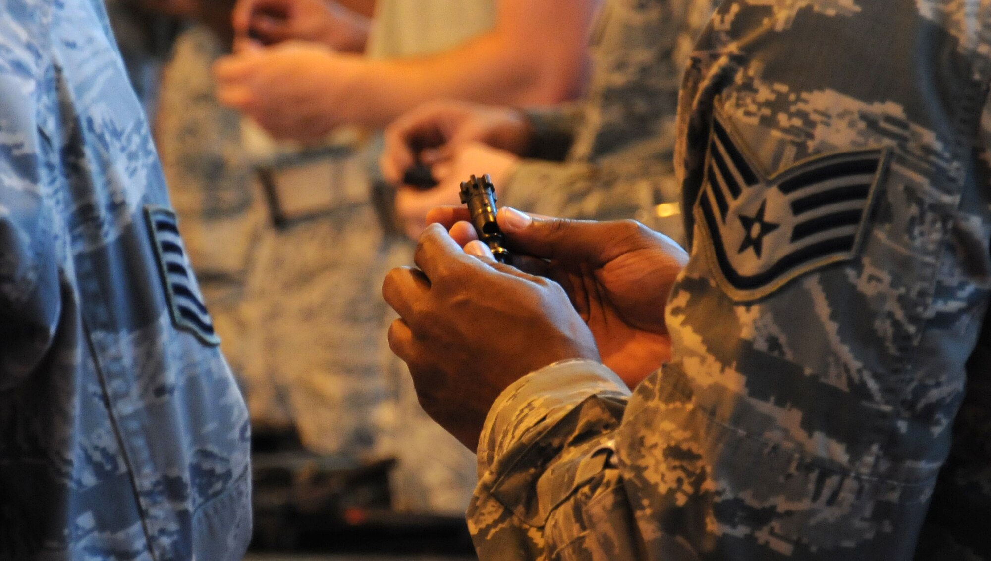 A Team Mildenhall member examines the components of a weapon during M16A2 familiarization training July 24, 2014, on RAF Mildenhall, England. Airmen from the 100th Security Forces Squadron taught Team Mildenhall members how to operate a weapon to ensure they are ready to defend the base and its population. (U.S. Air Force photo/Gina Randall/Released)