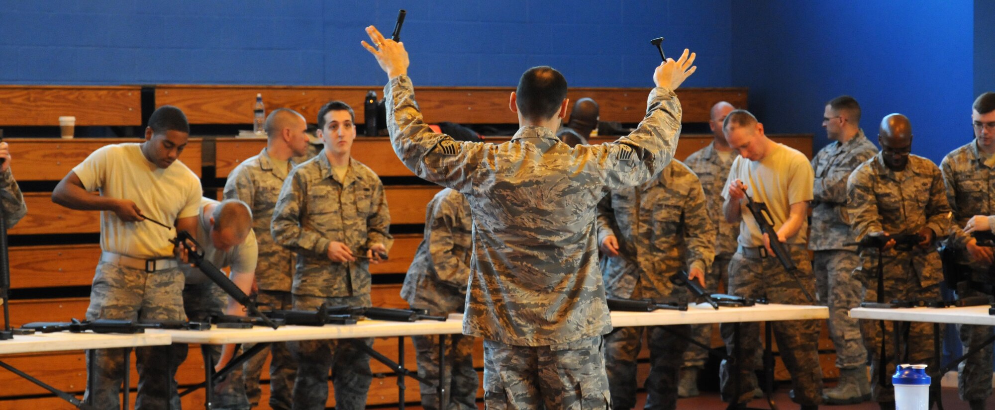 U.S. Air Force Staff Sgt. Joshua Garcia, center, 100th Security Forces Squadron NCO in charge of the armory from El Paso, Texas, demonstrates how to build and operate a weapon during training July 24, 2014, on RAF Mildenhall, England. Garcia taught Team Mildenhall members how to safely operate a weapon during M16A2 familiarization training. (U.S. Air Force photo/Gina Randall/Released)