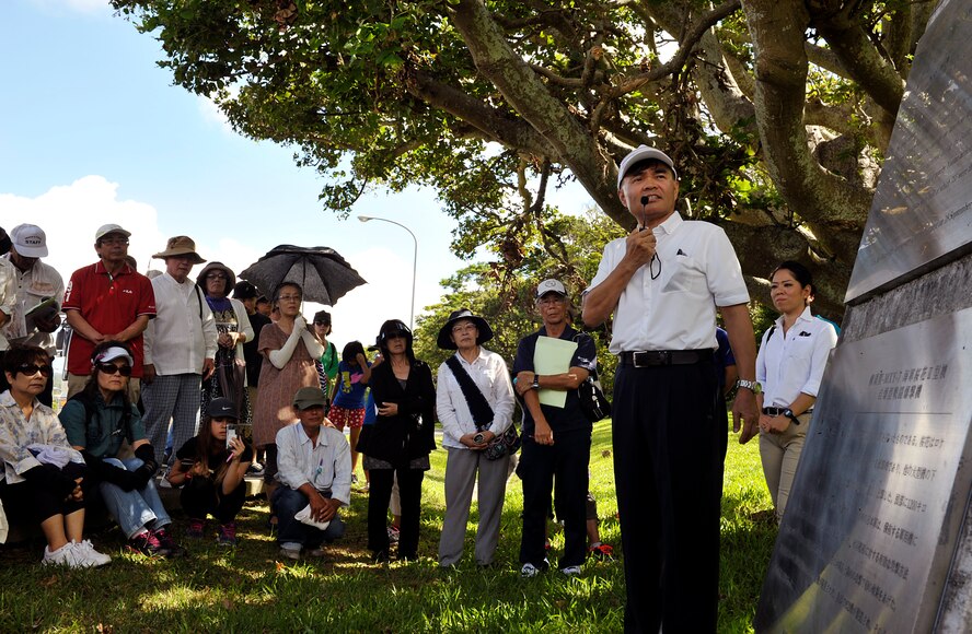 Hideaki Sakihama, 18th Wing Public Affairs community relations specialist, informs Okinawa City citizens about the history of the World War II Japanese aircraft hangars during an annual historical site visit on Kadena Air Base, Japan, July 29, 2014. This was the 21st annual historical site visit on Kadena. More than 90 Okinawa City citizens and nine students from Toyonaka City, Osaka, visited three war-related sites. (U.S. Air Force photo by Naoto Anazawa/Released)
