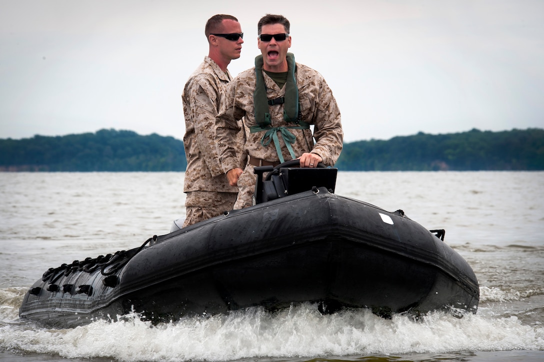 Marine Corps Gunnery Sgt. Michael D. Brown, foreground, calls out directions during an amphibious assault operation on the Potomac River on Marine Corps Base Quantico, Va., July 21, 2014. Brown is assigned to Echo Company, 4th Reconnaissance Battalion. The training exercise was part of a weeklong jump, dive, breach and shooting package conducted around various ranges on the base.