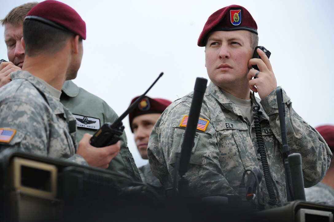 Army Sgt. Rex Ely, right, coordinates an airborne drop from the ground ...