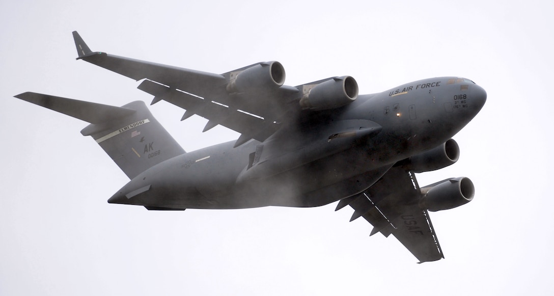 A C-17 Globemaster III aircraft makes a low pass during the Arctic Thunder Open House on Joint Base Elmendorf-Richardson, Alaska, July 25, 2014. The base hosted the biennial event, which featured more than 40 Air Force, Army and civilian aerial acts, and was expected to draw more than 200,000 people.