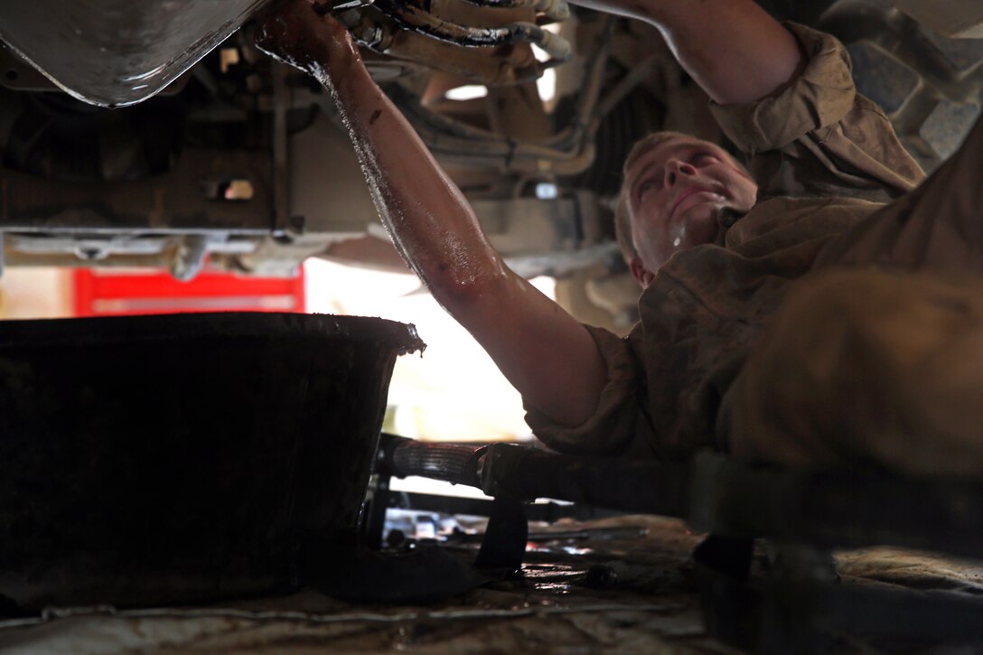 U.S. Marine Corps Lance Cpl. Matthew Whitaker conducts maintenance from underneath a mine-resistant, ambush-protected vehicle on Camp Leatherneck, Afghanistan, July 22, 2014. Whitaker, a motor transportation mechanic, is assigned to 1st Battalion, 7th Marine Regiment.