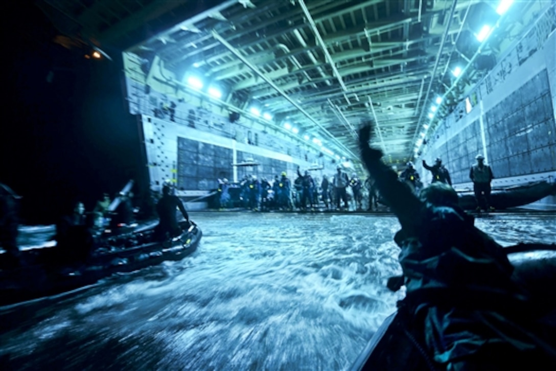 U.S. sailors and divers from New Zealand, the Netherlands, Canada, Japan, Australia and Chile recover their boats into the well deck of the amphibious transport dock ship USS Anchorage after conducting night dives off the coast of San Diego during Rim of the Pacific 2014, an exercise in the Pacific Ocean, July 18, 2014. The U.S. sailors are assigned to Explosive Ordnance Disposal Mobile Unit 1. 