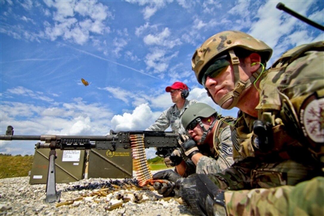 U.S. airmen fire an M240 machine gun during Operation Kriegshammer at Grafenwoehr Training Area in Bavaria, Germany, July 15, 2014. 