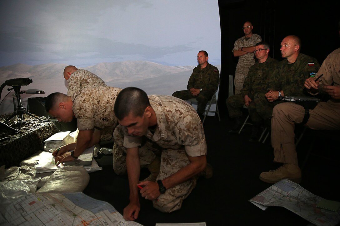 Capt Jorge Colon, fire support coordinator, 3rd Light Armored Reconnaissance Battalion, Capt. Joel Katz, forward air controller, 3rd LAR, and Sgt. Michael A. Kinne, fires faculty advisor, Marine Corps Tactics and Operations Group, conduct preparations before a fire support team exercise for Polish Army officers at the Supporting Arms Virtual Trainer, July 28, 2014.


