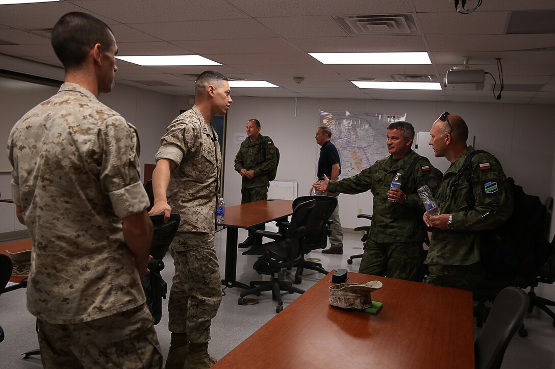 Capt Jorge Colon, fire support coordinator, 3rd Light Armored Reconnaissance Battalion, and Capt. Joel Katz, forward air controller, 3rd LAR, speak to Polish Army officers on their roles in their units after a demonstration at the Supporting Arms Virtual Trainer, July 28, 2014.


