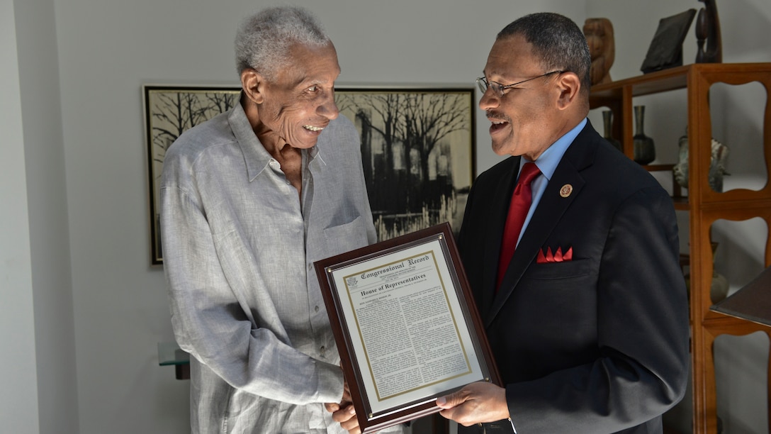 Lt. Gen. Frank E. Petersen, Jr. (ret.), left, handshakes U.S. Rep. Sanford D. Bishop, Jr., as he is presented a Congressional Record statement in honor of his significant accomplishments throughout his military career at his home in Stevensville, Maryland July 28. 