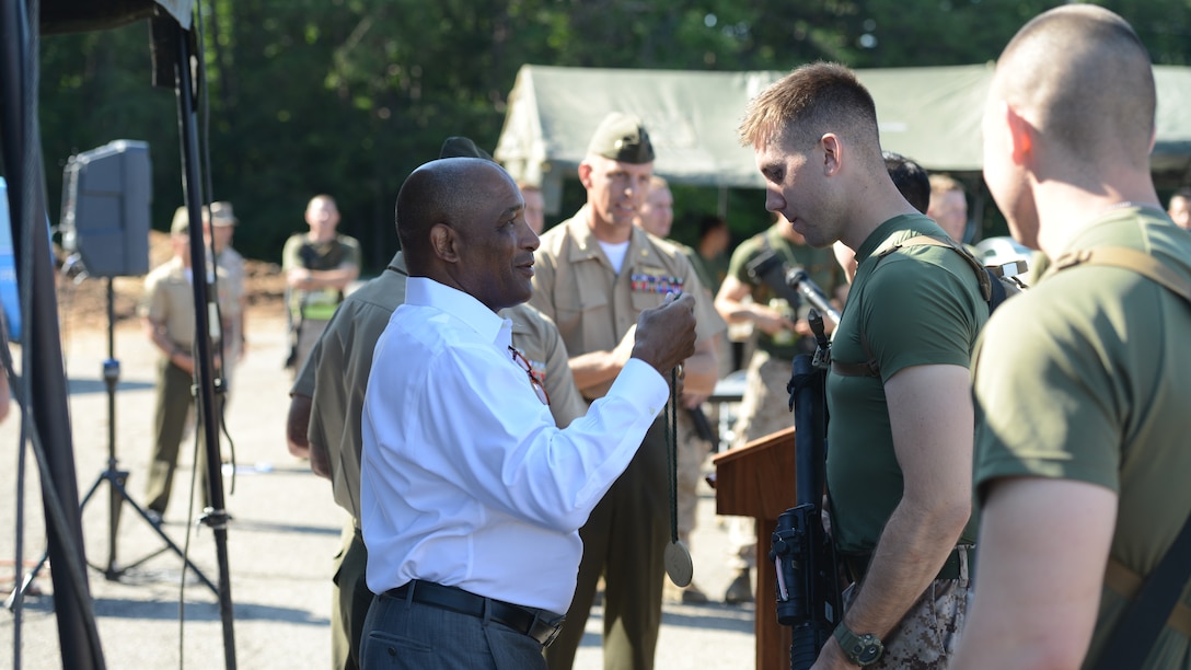 Ronald S. Coleman, a retired Marine lieutenant general, presents medals to competitors during the 2nd Annual Montford Point Biathlon at Marine Corps Base Quantico, Virginia, July 25, 2014.  The top three performing teams were recognized and awarded a medal, followed by the fastest individual time and best individual shooters during the competition. 