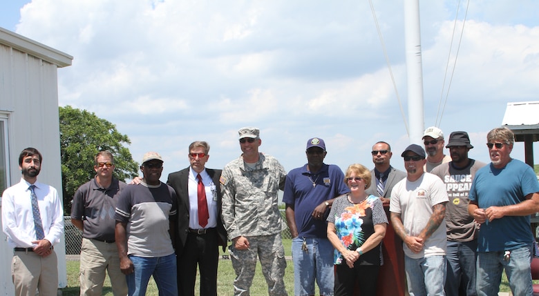 (l-r) Jorel Nadal, David Wright, Wilroy Pretlow, Dan DeWease, OSHA regional director, Col. Paul Olsen, Norfolk District commander, Bernard Jackson, Terrie Simmons, Carlos Quinones, Travis Butler, George Kellison, Craig Lewis, and Terry Bass celebrate during the Craney Island VPP Star flag-raising ceremony, held July 10.
