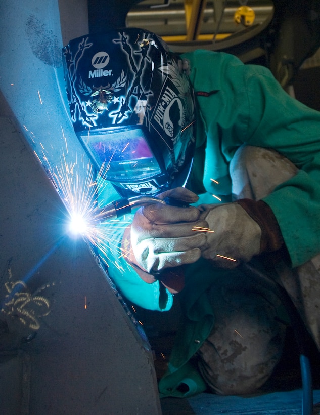 Marine reservist Lance Cpl. Cody Cole, metal worker, Heavy Equipment Platoon, 6th Engineering Support Company, 6th Engineering Support Battalion, Battle Creek, Michigan, fills in gouges by melting new metal inside the interior hull of a light armored vehicle, Friday, as part of his two-week annual training at Marine Corps Logistics Base Albany, Georgia.