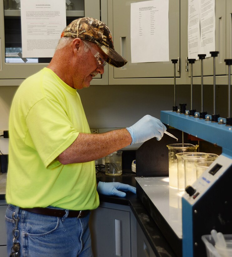Steve Nelson, industrial waste water operator, Industrial Waste Treatment Plant, Public Works, Installation and Environment Division, adds treatment chemicals during a jar test at the IWTP’s lab. A jar test is conducted every shift to make sure the plant is operating correctly.