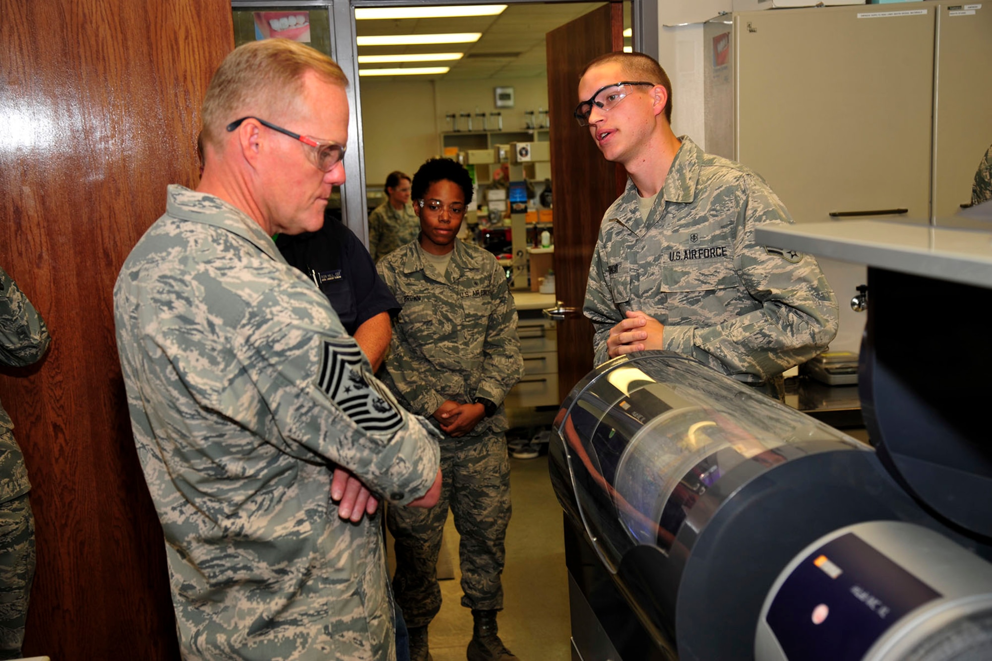 Senior Airman Daniel Longar describes dental procedures with Chief Master Sgt. of the Air Force James Cody July 25, 2014, at the dental clinic at Peterson Air Force Base, Colo. During his visit, Cody toured the base, visited with and thanked Airmen, hosted two Airmen’s calls, and discussed the challenges and rewards of being in the Air Force today. Longar is with the 21st Dental Squadron. (U.S. Air Force photo/Robb Lingley)