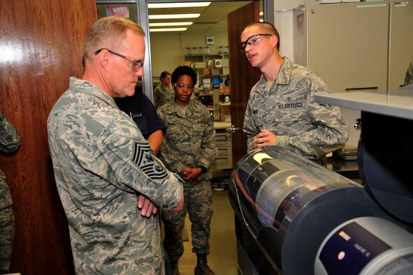Senior Airman Daniel Longar describes dental procedures with Chief Master Sgt. of the Air Force James Cody July 25, 2014, at the dental clinic at Peterson Air Force Base, Colo. During his visit, Cody toured the base, visited with and thanked Airmen, hosted two Airmen’s calls, and discussed the challenges and rewards of being in the Air Force today. Longar is with the 21st Dental Squadron. (U.S. Air Force photo/Robb Lingley)