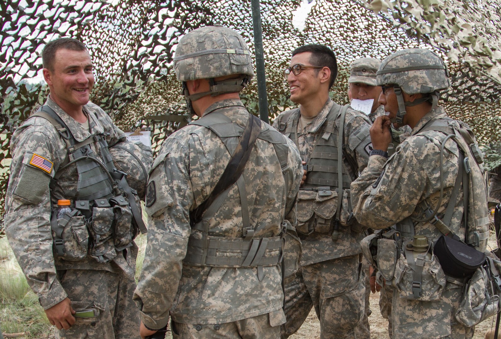 Arizona Army National Guard Soldiers joke with each other while waiting to be tested at the next Expert Infantry Badge station at Camp Navajo, Ariz., July 23, 2014.