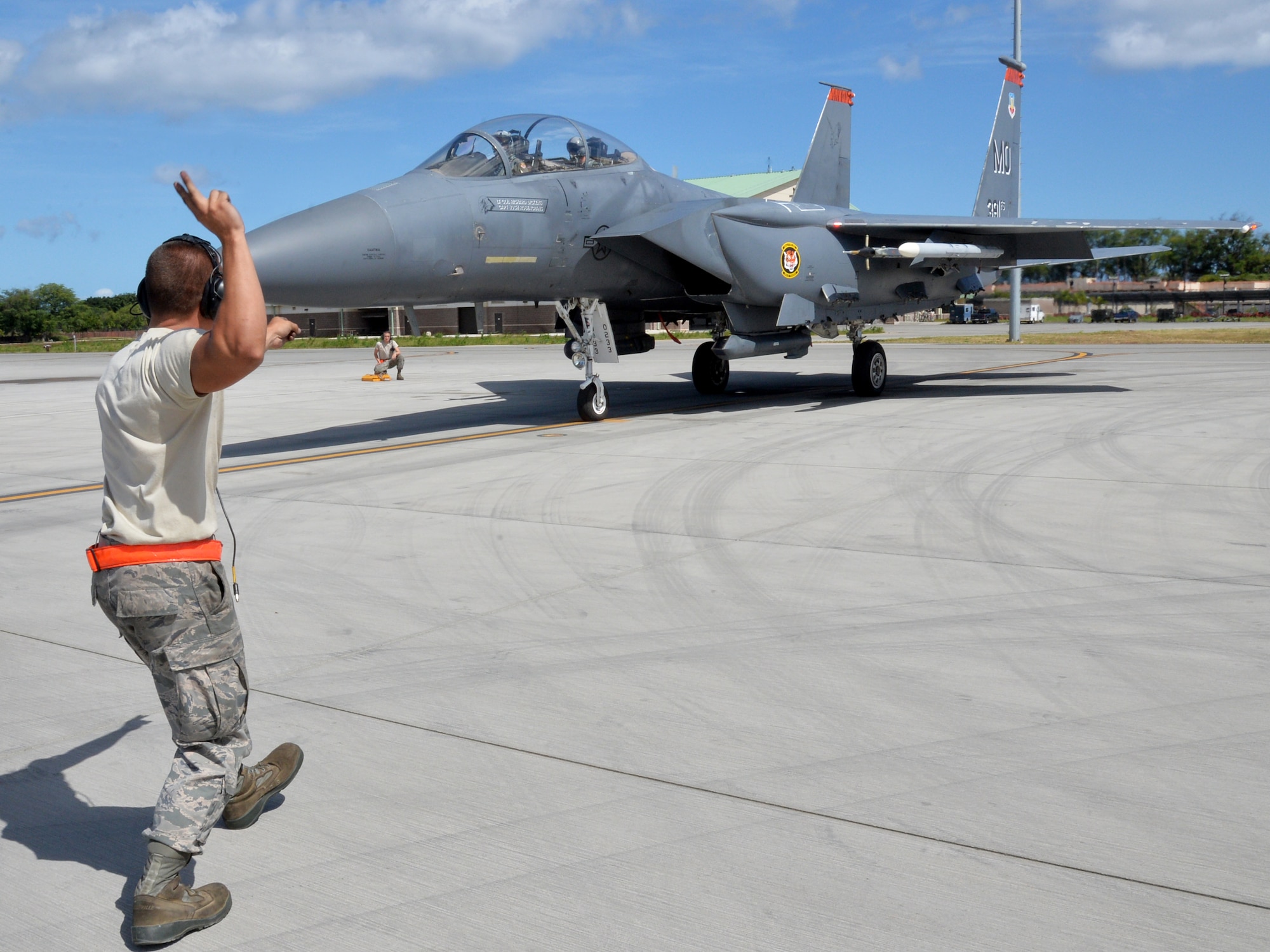 Senior Airman Kenneth Comfort  guides an F-15E Strike Eagle during a mission July 16, 2014, at Joint Base Pearl Harbor-Hickam, Hawaii. The 391st Fighter Squadron is currently on a two-month deployment here from Mountain Home Air Force Base, Idaho. While here, the squadron’s F-15Es have participated in Rim of the Pacific 2014 exercise missions. RIMPAC is a U.S. Pacific Command-hosted biennial multinational maritime exercise designed to foster and sustain international cooperation on the security of the world’s oceans. Comfort is a 391st FS crew chief. (U.S. Air Force photo/Staff Sgt. Alexander Martinez)
