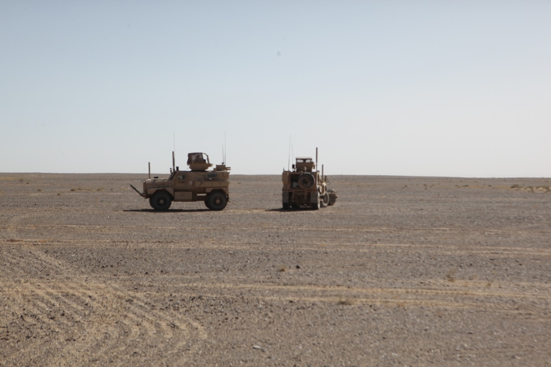Two teams of Marines with Charley Company, 1st Battalion, 7th Marine Regiment, with Mine-Resistant Ambush Protected vehicles provide security during an operation in Helmand province, Afghanistan, July 19, 2014. During the two-day operation, Marines with Charley Co. watched over nearby routes close to Camp Dwyer and the surrounding area to help mitigate enemy insurgents smuggling small arms weapons and explosive material through the area. (U.S. Marine Corps photo by Cpl. Cody Haas/ Released)
