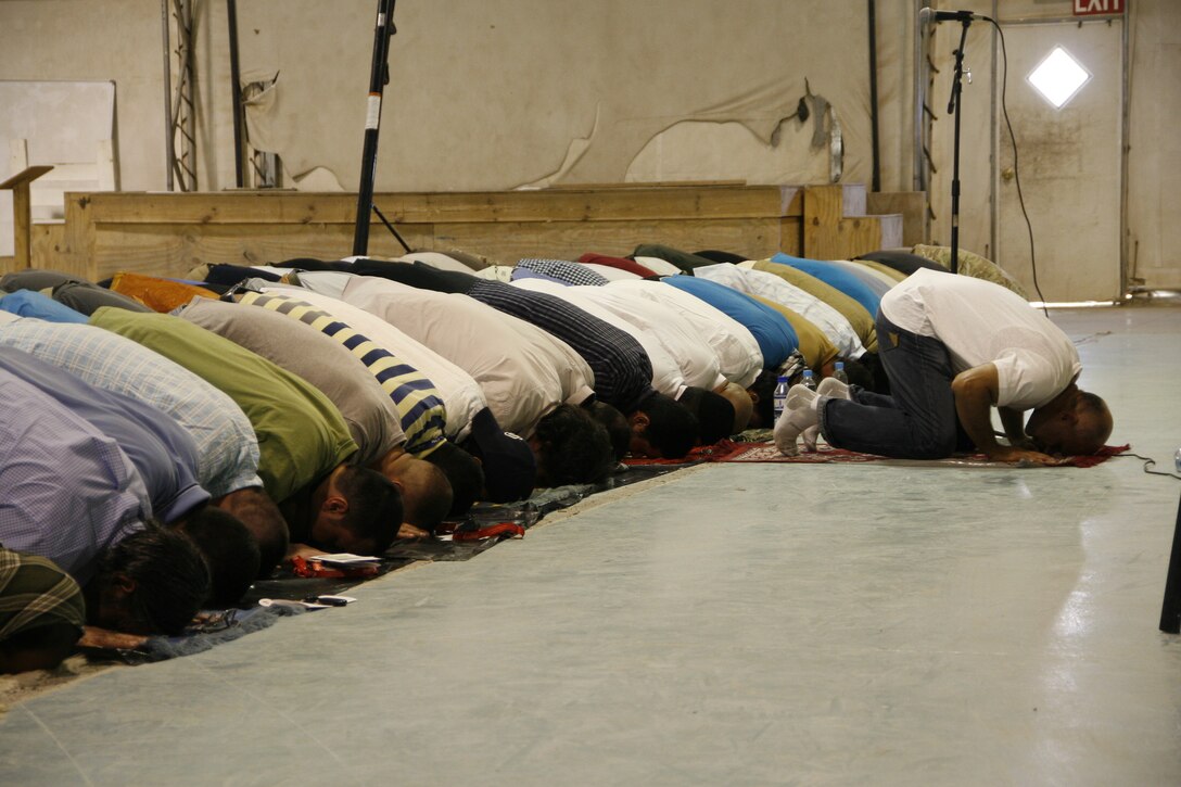Coalition service members and civilian contractors pray during an Eid al-Fitr ceremony held aboard Camp Leatherneck, Helmand province, Afghanistan, July 28, 2014. The ceremony marked the end of Ramadan, which is a monthlong holiday that millions of Muslims observe each year by fasting from morning to evening.