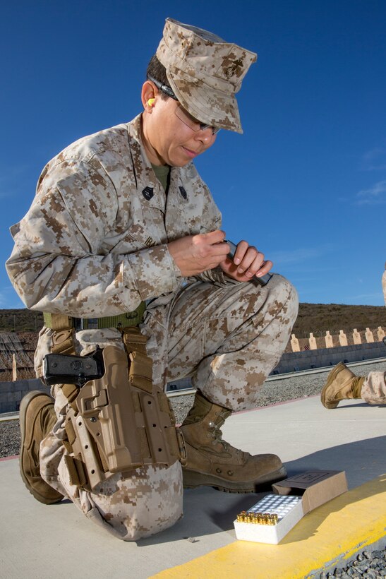 Gunnery Sgt. Erika Ibarra, engine log and records chief with Marine Aviation Logistics Squadron (MALS) 11, reloads a pistol magazine before another course of fire at Carlos Hathcock Range Complex aboard Marine Corps Air Station Miramar, Calif., July 29. The Corps’ latest pistol marksmanship qualification, the Combat Pistol Program, was implemented October 2013 and allows marksmanship coaches Corpswide to make training more realistic for the thousands of Marines and Sailors who qualify annually.