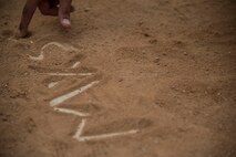 A member of the 8th Maintenance Squadron Dragons writes the teams name on the field after the squadron championship softball game at Kunsan Air Base, Republic of Korea, July 30, 2014. The game’s final score ended with the Dragons taking the win, 14 to 9. (U.S. Air Force photo by Staff Sgt. Jose Rodriguez/Released)