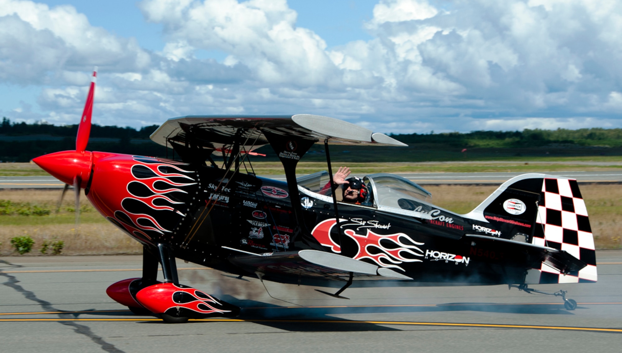 Skip Stewart waves to the crowd after his aerial demonstration during the Arctic Thunder Open House on Joint Base Elmendorf-Richardson, Alaska, July 26, 2014. The event features more than 40 Air Force, Army and civilian aerial acts, July 25-27, and has an expected crowd of more than 200,000 people. It is the largest two-day event in the state and one of the premier aerial demonstrations in the world. The 2014 Arctic Thunder Open House is a proud part of the Anchorage Centennial Celebration. (U.S. Air Force photo/Airman 1st Class Tammie Ramsouer)