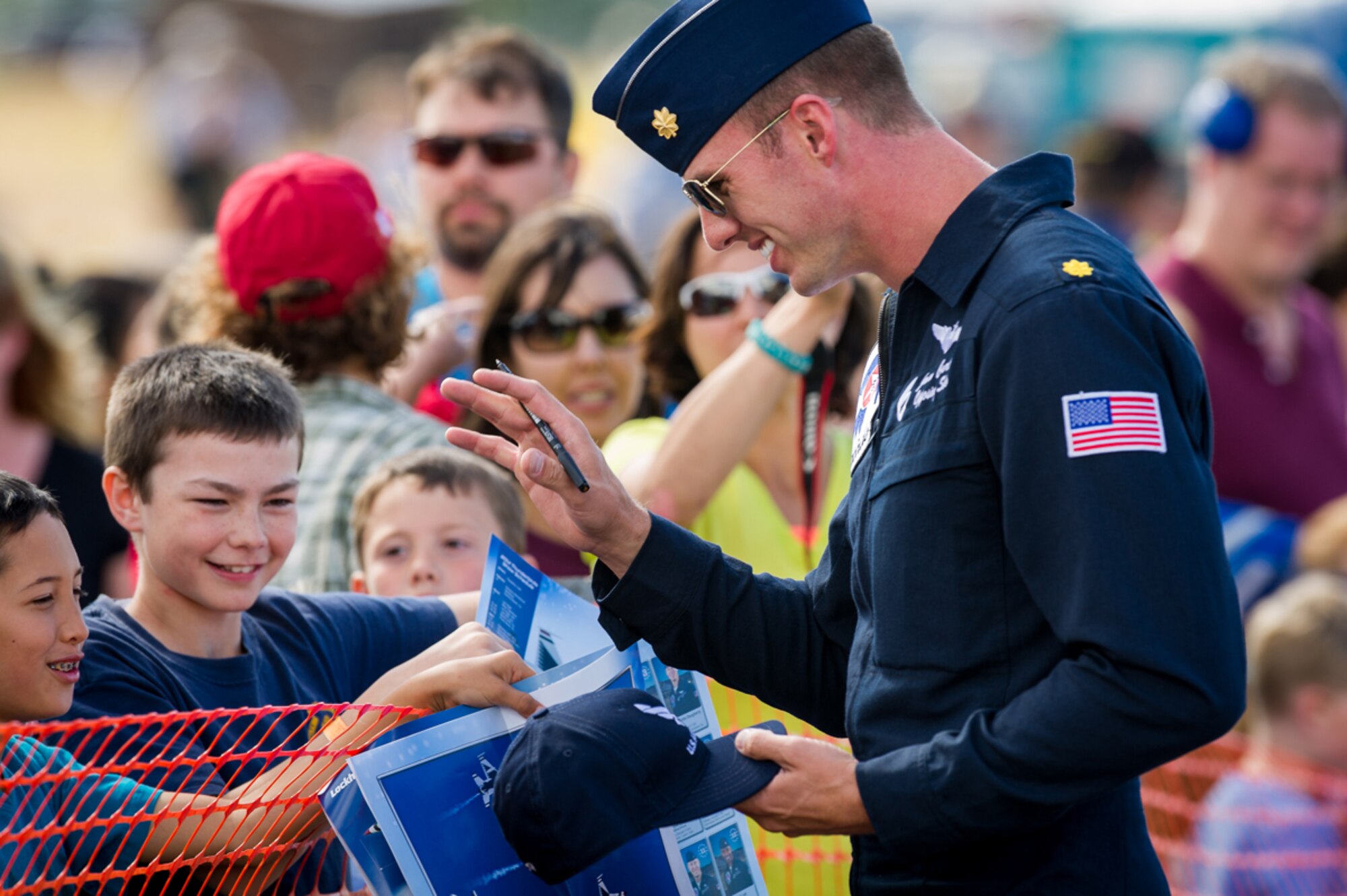 The U.S. Air Force Thunderbirds Maj. Jason Curtis, Thunderbird 6, Opposing Solo, interacts with fans following the performance at the Arctic Thunder Open House biennial event hosted by Joint Base Elmendorf-Richardson, Alaska, July 26, 2014. Arctic Thunder is a biennial event hosted by JBER. Featuring more than 40 Air Force, Army and civilian aerial acts and an expected crowd of more than 200,000 people, it is the largest two-day event in the state and one of the premier aerial demonstrations in the world. The 2014 Arctic Thunder Open House is a proud part of the Anchorage Centennial Celebration. (U.S. Air Force photo by Master Sgt. John R. Nimmo, Sr./Released)