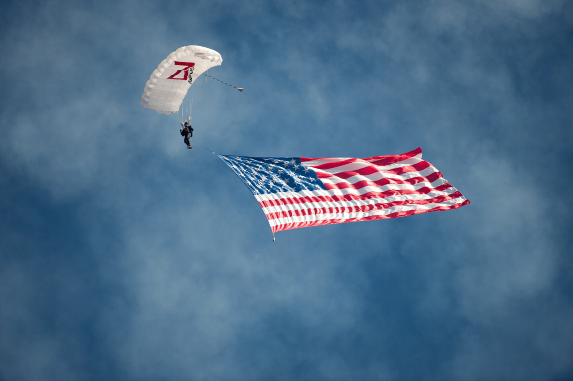 JOINT BASE ELMENDORF-RICHARDSON, Alaska - Rex Pemberton opens the Arctic Thunder Open House by skydiving from 3,000 feet and deploys the American Flag at 1,500 feet, July 26,2014. Arctic Thunder is a biennial event hosted by Joint Base Elmendorf-Richardson, Alaska. Featuring more than 40 Air Force, Army and civilian aerial acts and an expected crowd of more than 200,000 people, it is the largest two-day event in the state and one of the premier aerial demonstrations in the world. The 2014 Arctic Thunder Open House is a proud part of the Anchorage Centennial Celebration -  (U.S. Air Force photo / Johnathon Green)
