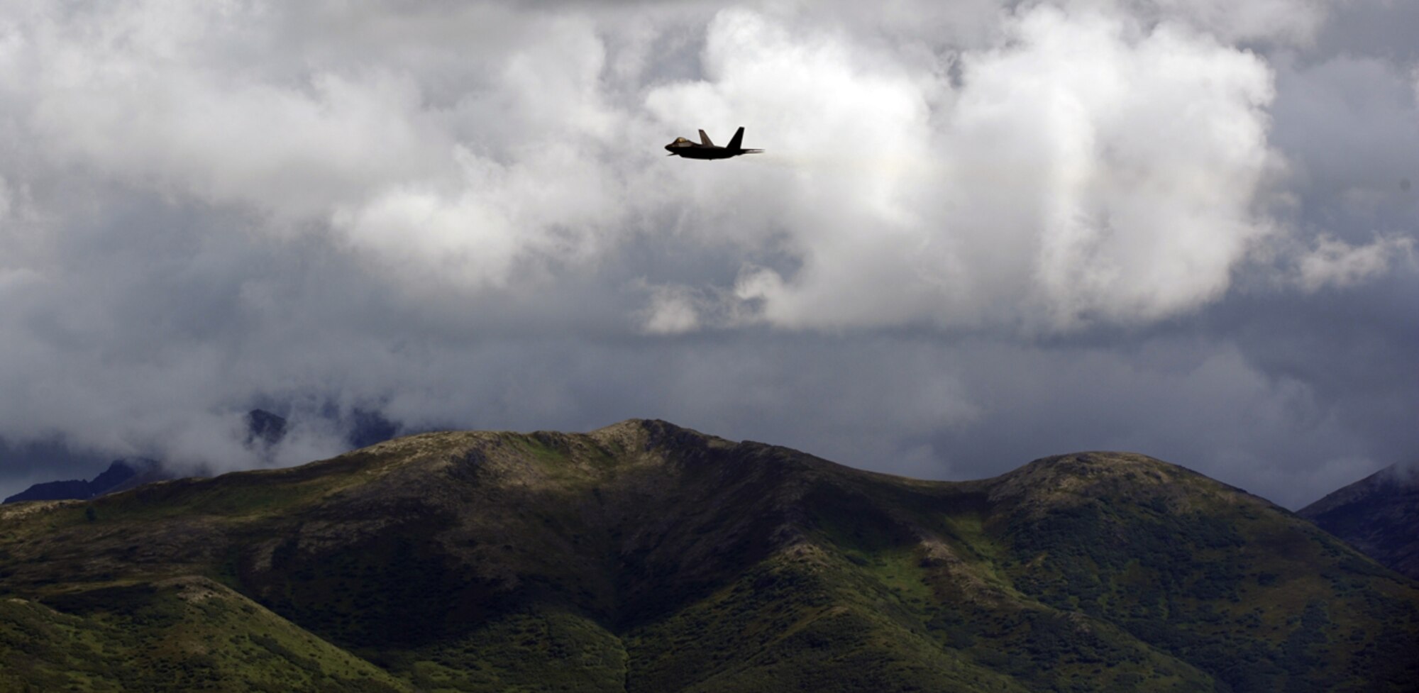 An F-22 Raptor speeds toward the crowd as the Chugach Range is seen in the distance during the Arctic Thunder Open House biennial event hosted by Joint Base Elmendorf-Richardson, Alaska, July 26, 2014. The event features more than 40 Air Force, Army and civilian aerial acts, July 25-27, and has an expected crowd of more than 200,000 people. It is the largest two-day event in the state and one of the premier aerial demonstrations in the world. The 2014 Arctic Thunder Open House is a proud part of the Anchorage Centennial Celebration.  (U.S. Air Force photo/Justin Connaher)