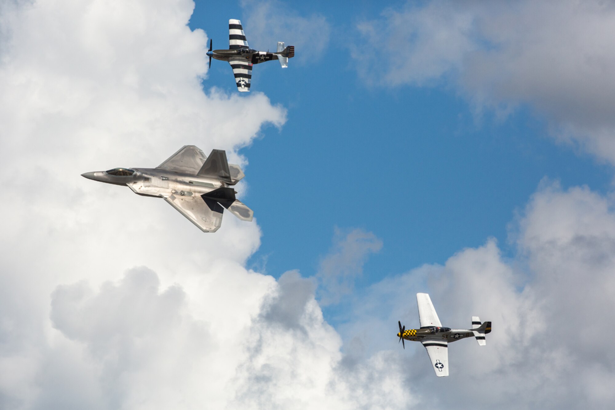 JOINT BASE ELMENDORF-RICHARDSON, Alaska - The Heritage Flight with an F-22 Raptor and two P-51 Mustang, flown by the Bremont Horsemen, demonstrate the proud military aviation heritage of the U.S. Air Force at Joint Base Elmendorf-Richardson's Arctic Thunder Open House 2014, July 26. The event features more than 40 Air Force, Army and civilian aerial acts, July 25-27, and has an expected crowd of more than 200,000 people. It is the largest two-day event in the state and one of the premier aerial demonstrations in the world. The 2014 Arctic Thunder Open House is a proud part of the Anchorage Centennial Celebration. (U.S. Air Force photo/Capt. Joel Cooke)