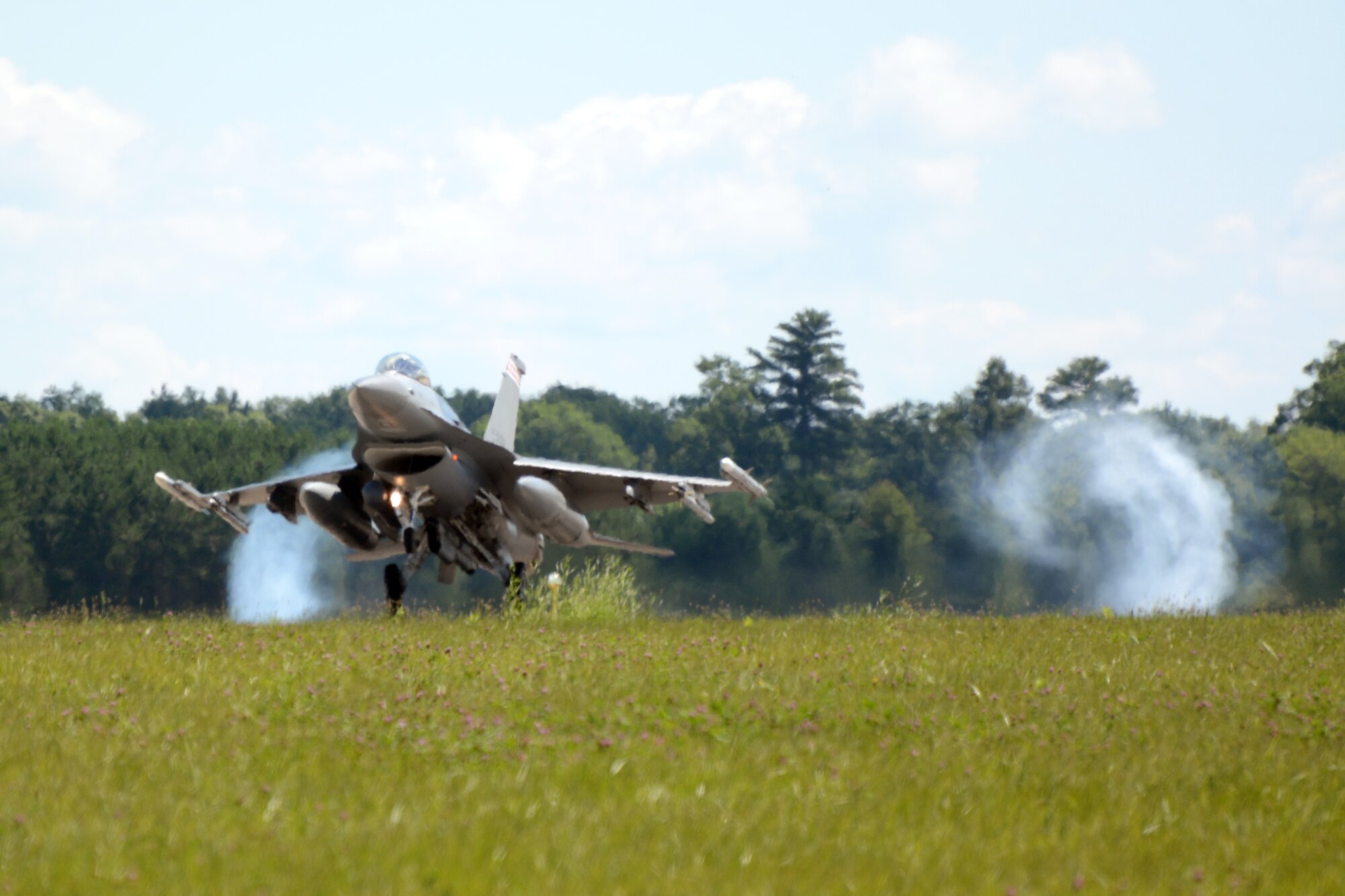 An F-16 Fighting Falcon from the 115th Fighter Wing in Madison, Wis., lands on the runway at Volk Field Air National Guard Base, Wis., July 16, 2014. The jets were moved to Volk Field for the month of July, while the Dane County Regional Airport completed runway maintenance and repairs. (Air National Guard photo by Senior Airman Andrea F. Liechti)