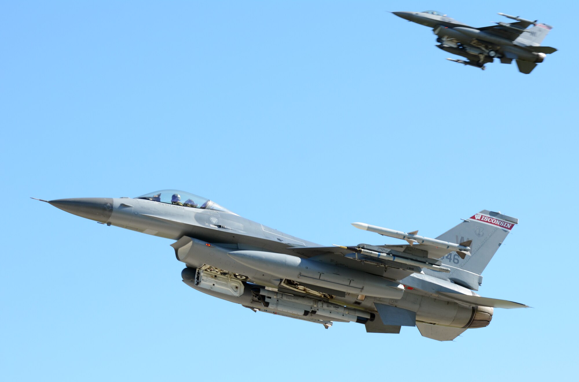 Two F-16 Fighting Falcons from the 115th Fighter Wing in Madison, Wis., perform flyover maneuvers prior to landing on the runway at Volk Field Air National Guard Base, Wis., July 16, 2014. The jets were moved to Volk Field for the month of July, while the Dane County Regional Airport completed runway maintenance and repairs. (Air National Guard photo by Senior Airman Andrea F. Liechti)