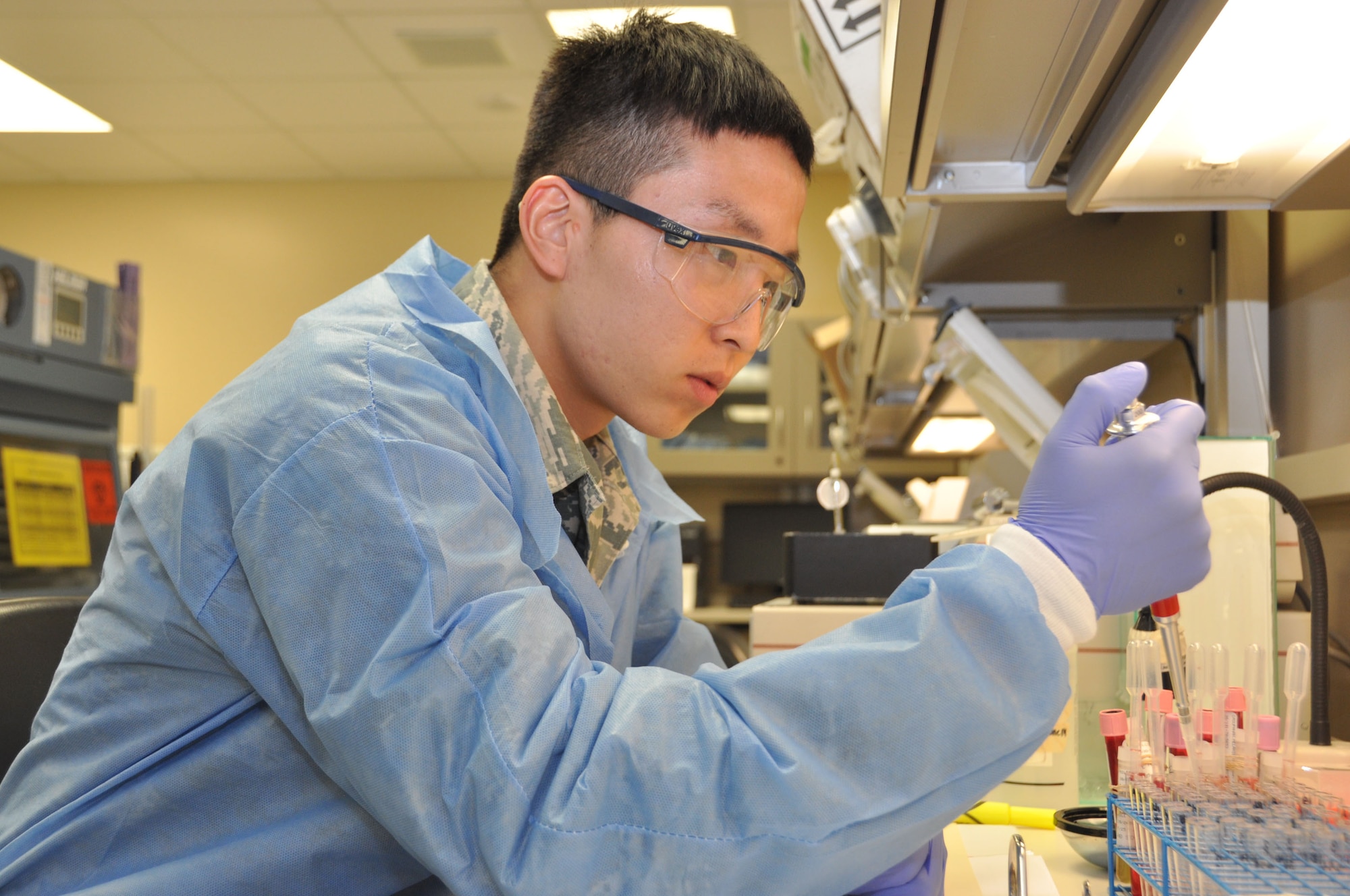Airman 1st Class Duckjin Park, a medical laboratory technician with the 60th Diagnostic and Therapeutic Squadron, uses a pipette at the David Grant Medical Center July 24 at Travis Air Force Base. Park, a South Korean native, was naturalized July 22, 2014. (U.S. Air Force photo by Airman 1st Class Amber Carter)