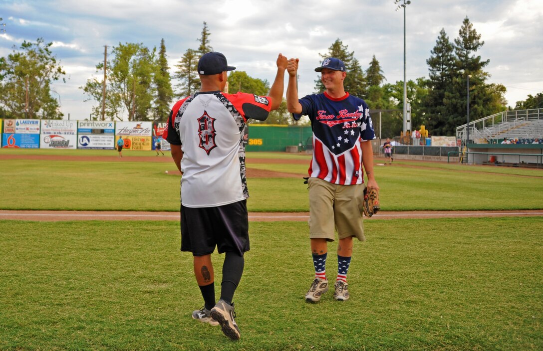 Senior Airman Richard Rivera (left) and Staff Sgt. Blake Anderson, Beale All-Stars team members, congratulate each other during a softball game with the Marysville Gold Sox July 30, 2014, at Appeal-Democrat Park in Marysville, Calif. More than 100 guests attended the softball game. (U.S. Air Force photo by Airman 1st Class Ramon A. Adelan/ Released)