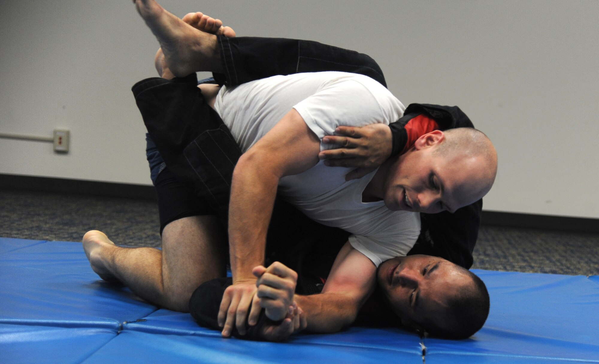 1st Lt. Jacob Pfannenstiel, top, and Tech. Sgt. Tony Eclavea grapple during a Brazilian Jiu Jitsu class in the Community Chapel Activity Center. Eclavea teaches the class every Tuesday and Thursday from 5 to 7 p.m. in the CCAC. The classes are open to anyone wanting to practice or learn. (U.S. Air Force photo/Senior Airman Frank Casciotta)
