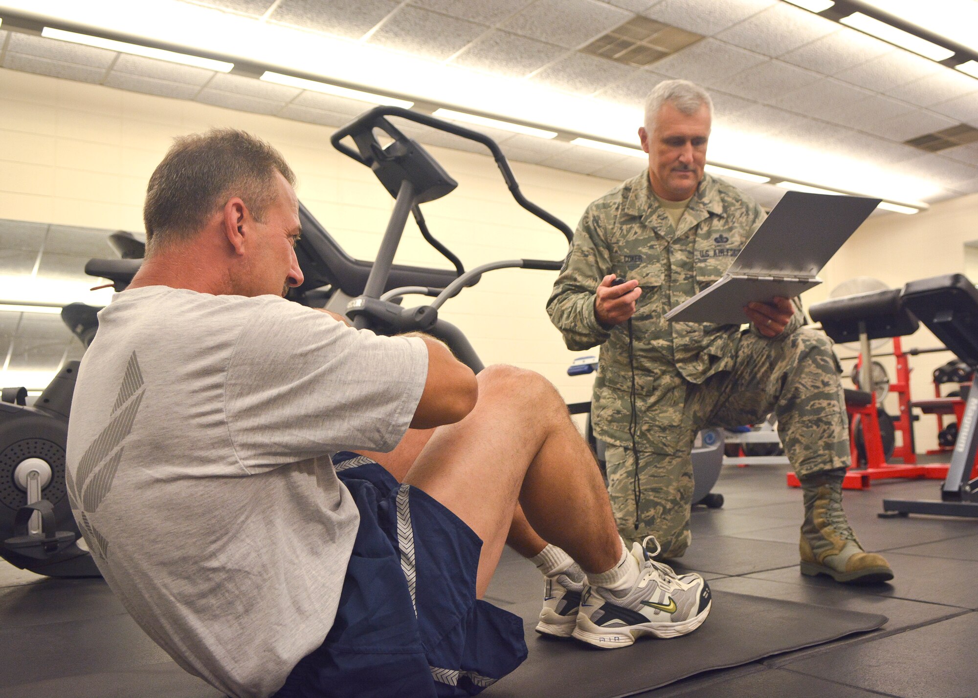 Master Sgt. David Coker, 128th Air Refueling Wing Fitness Program Manager, conducts a fitness test for a 128th Airman at General Mitchell Air National Guard Base, Wisc., July 23, 2014. Coker, who takes on the Honor Guard program as an additional duty, is the ANG's 2014 Outstanding Honor Guard Program Manager of the Year. (U.S. Air National Guard photo by Senior Master Sgt. Jeffrey A. Rohloff/Released)