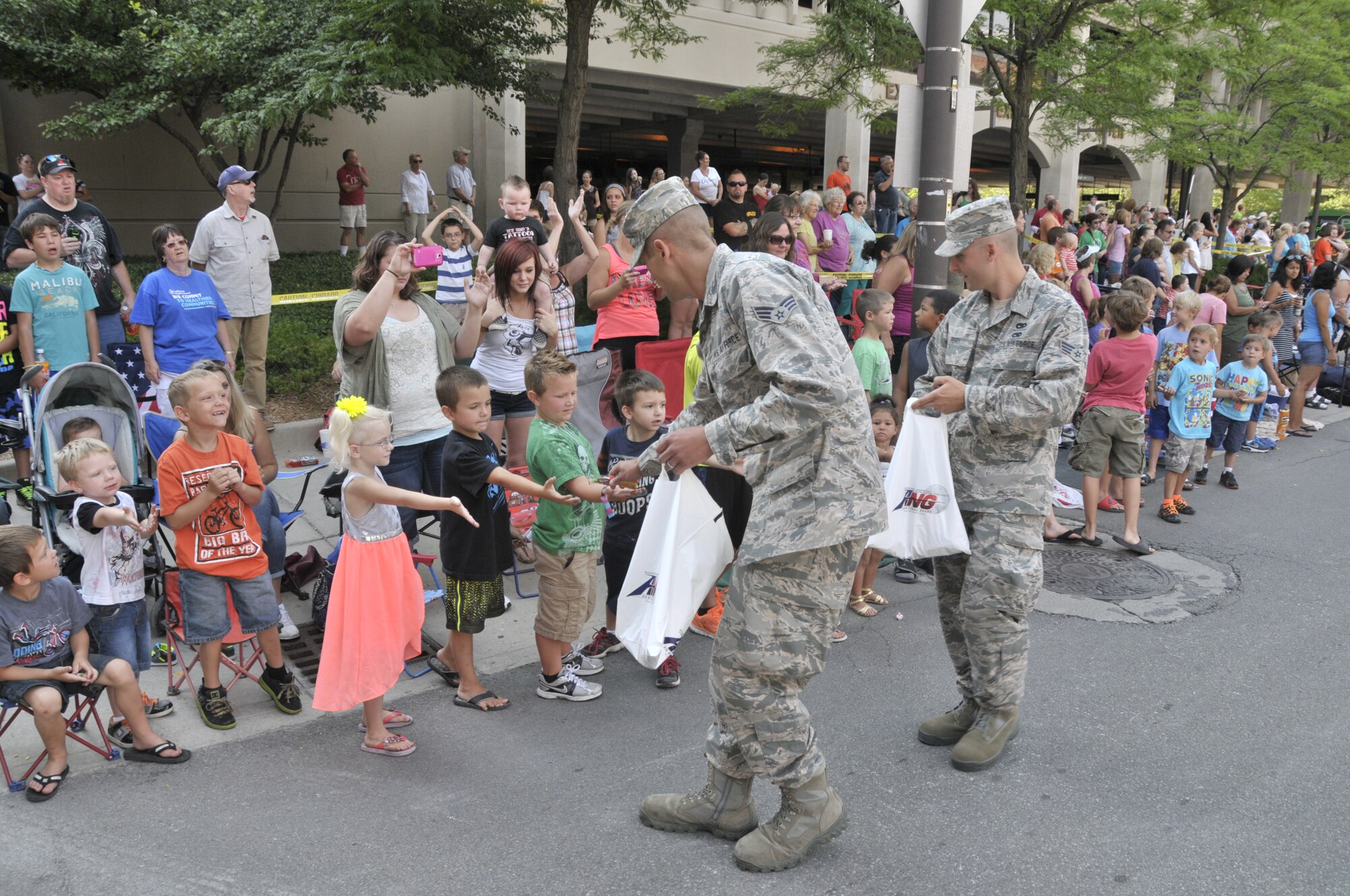 Air Guard members from the 122nd Fighter Wing, Fort Wayne, Indiana hand out candy to spectating children during the 46th Annual Three Rivers Festival Parade, July 12, 2014, held on the streets of downtown Fort Wayne. The yearly parade, attended by approximately 50,000 people, allows the wing to show its community support. (Air National Guard photo by Airman 1st Class Justin Andras/Released)