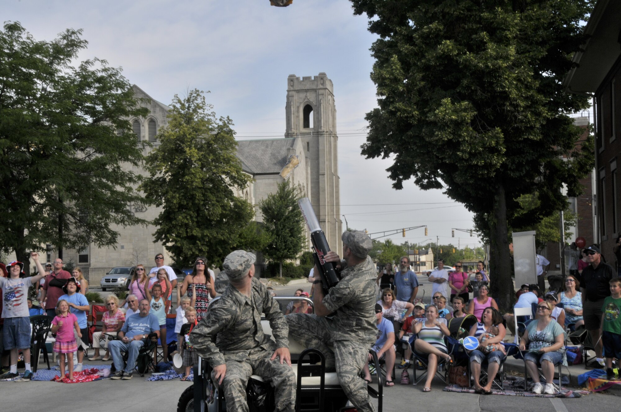 Air Guard members from the 122nd Fighter Wing, Fort Wayne, Indiana shoot T-shirts into the crowd at the 46th Annual Three Rivers Festival Parade, July 12, 2014, in the streets of downtown Fort Wayne. The yearly parade, attended by approximately 50,000 people, allows the wing to show its community support. (Air National Guard photo by Airman 1st Class Justin Andras/Released)