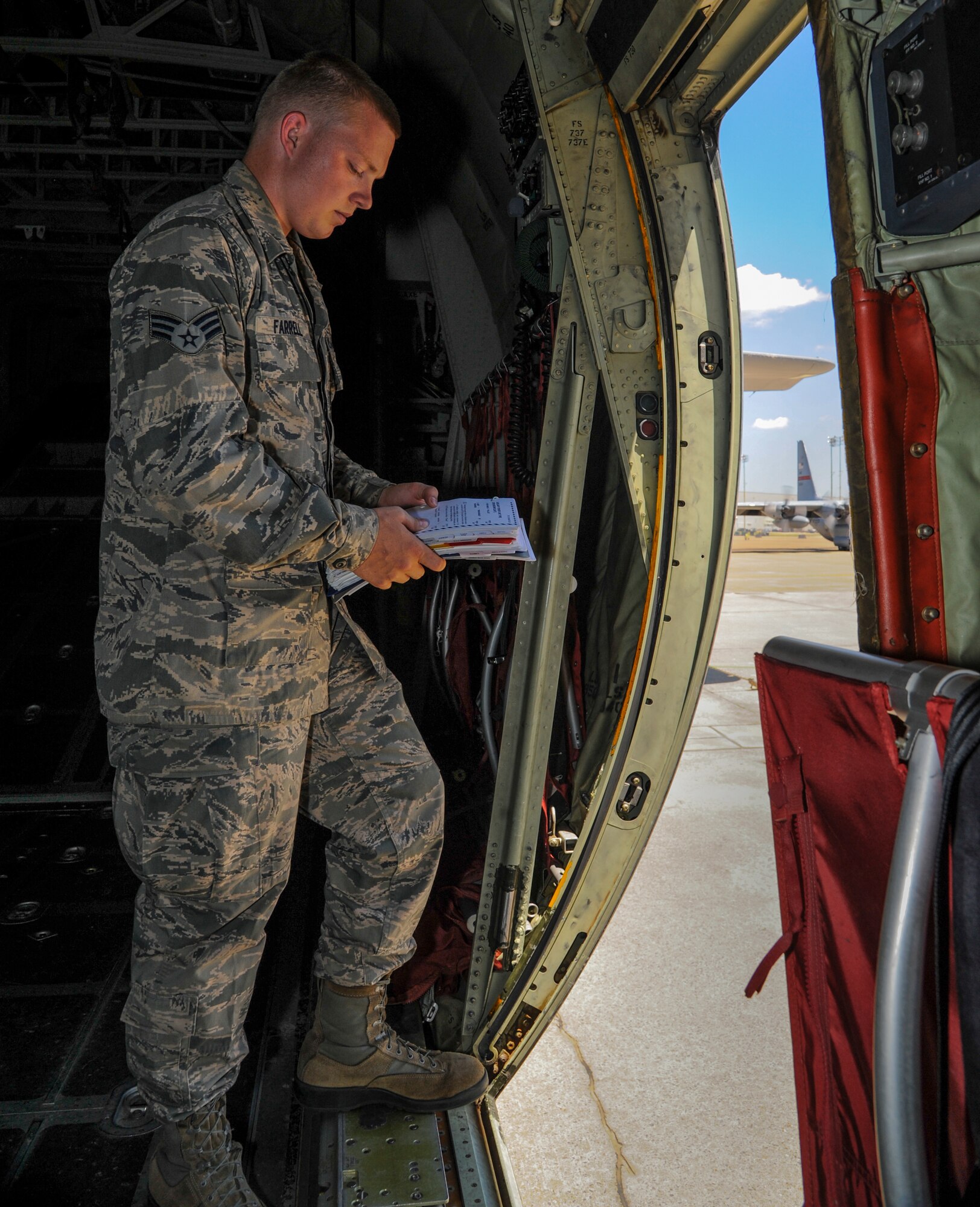 Senior Airman Tyler Farrell, a 61st Airlift Squadron C-130J loadmaster, reviews a pre-flight checklist July 29, 2014, at Little Rock Air Force Base, Ark. Farrell was selected two years ahead of his peers to attend the C-130J instructor and Joint Airlift Inspector courses. (U.S. Air Force photo by Airman 1st Class Harry Brexel)