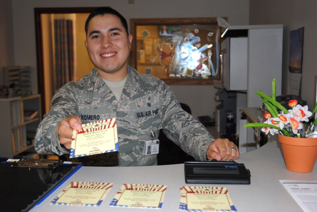 Senior Airman Andrew Romero, 319th Medical Operations Squadron immunizations technician, spreads the news about an upcoming blood drive on base by handing a flyer to a patient on July 31, 2014,at the immunizations section of the medical treatment facility on Grand Forks Air Force Base, N.D. The 319th Medical Group is partnering with DAK MINN Blood Bank to help local hospital patients with a blood drive. The drive is scheduled to take place Aug. 6, 2014, inside Sven’s Den at the Prairie Rose Chapel from 9 a.m. to 3 p.m. (U.S. Air Force photo/Staff Sgt. Luis Loza Gutierrez)