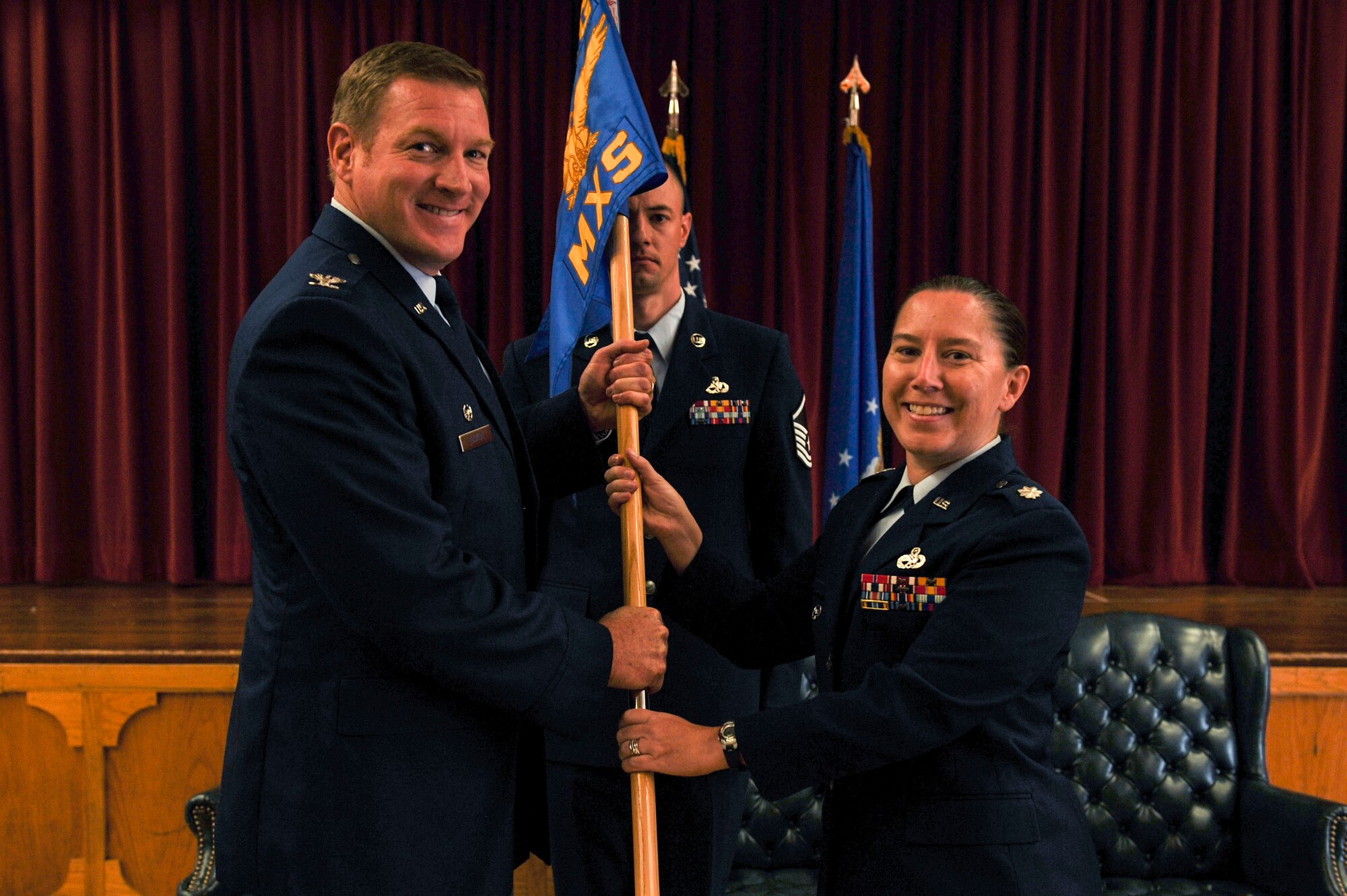 Col. Daniel Lockert, 19th Maintenance Group commander, passes the guidon to Lt. Col. Heather Cooley, 19th Maintenance Squadron commander, July 16, 2014, at Little Rock Air Force Base, Ark. The 19th Component Maintenance Squadron was inactivated, and its personnel merged with the 19th Equipment Maintenance Squadron; the 19th EMS was then redesigned as the 19th Maintenance Squadron. (U.S. Air Force photo by Airman 1st Class Cliffton Dolezal)