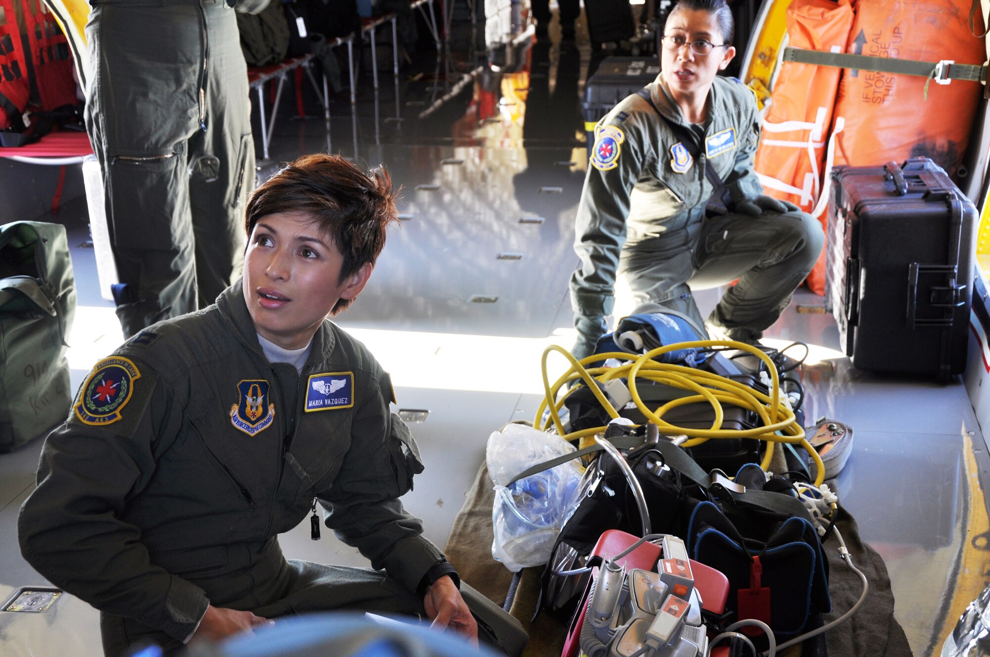 Capt. Maria Vazquez, 349th Aeromedical Evacuation Squadron medical director, and Capt. Janette Williford, 349th AES DOA, are debriefed after controlling a simulated fire on a McConnell KC-135 Stratotanker, July 25, 2014.   The unit typically utilizes two to three missions a month, simulating a variety of aircraft emergencies, including fires which require the AETs to don MA1 Oxygen bottles and their quick don gas masks.  (U.S. Air Force photo by Staff Sgt. Abigail Klein)