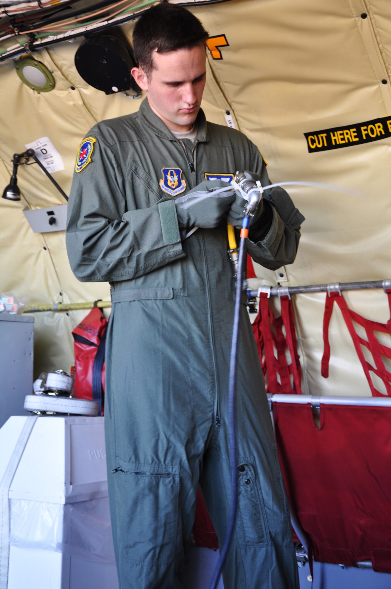 Senior Airman Nicholas Andermahr, 349th Aeromedical Evacuation Squadron technician, preps his "patients'" during an aeromedical evacuation exercise on a McConnell KC-135 Stratotanker, July 25, 2014.  Like most AET Airmen, Andermahr has to master the difficult task of rapidly setting up medical equipment in variety of aircraft, including a C-17 Globemaster, and a C-130 Hercules.  (U.S. Air Force photo by Staff. Sgt. Abigail Klein)