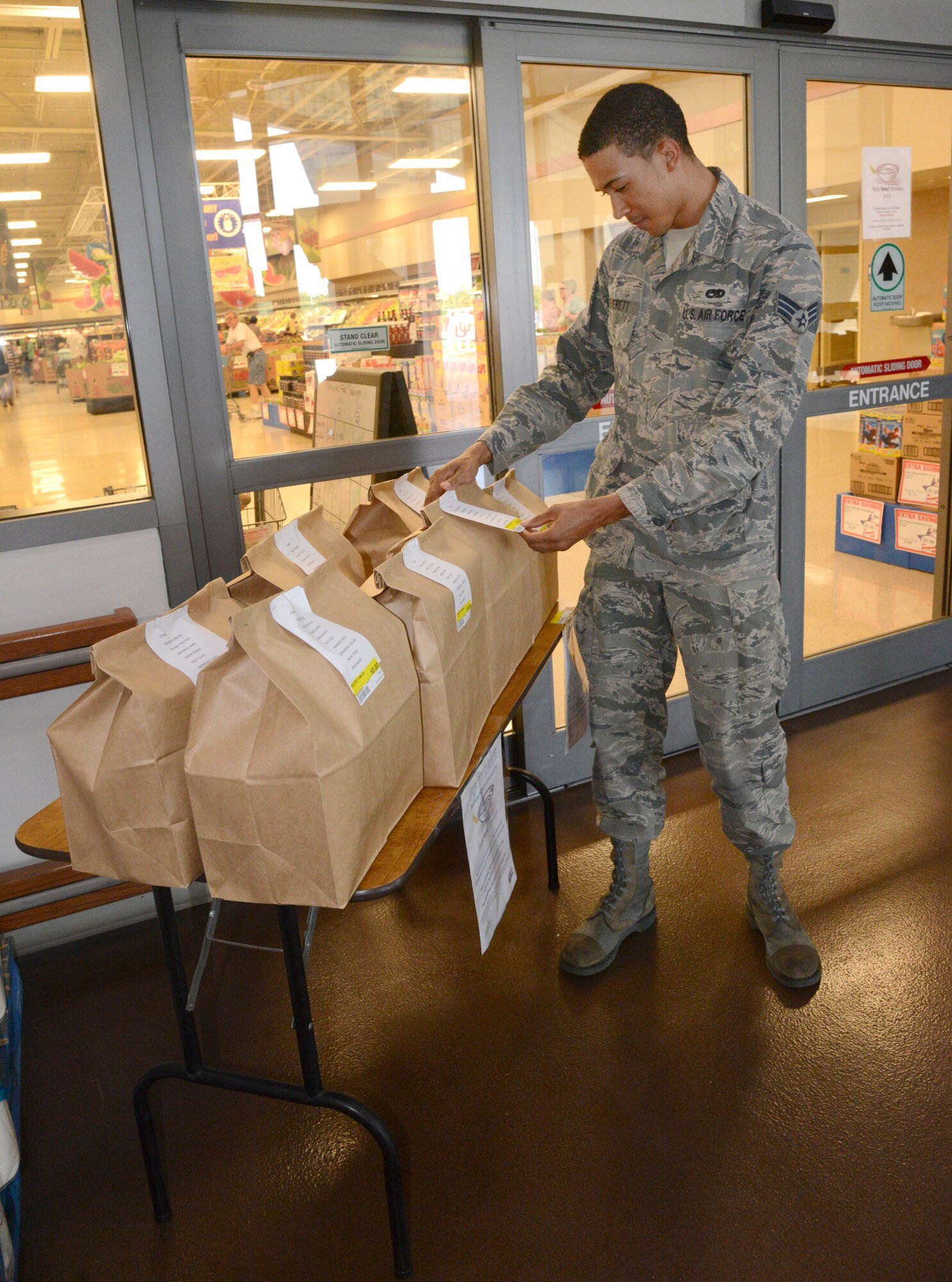 Senior Airman Gregory Everett, with the 552nd Aircraft Maintenance Squadron, checks out pre-packaged bags of non-perishable food items which are available for purchase at the front entrance of the Tinker Commissary for $10 each to support the Feds Feed Families campaign. The campaign is available for any federal employee, spouse or retiree to donate to local food banks, with Tinker donations going to food banks to support Midwest City and Del City. Non-perishable food donation drop-off points are at the Commissary, the Med Group Clinic, 72nd Air Base Wing Headquarters in Bldg. 460 and Bldg. 7017 (Fire Station 4 in the old 3rd Herd Compound).